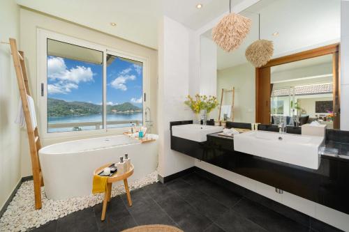 baño con 2 lavabos y ventana grande en Stunning 5 bedrooms Villa with Panoramic Sea View, en Por Bay