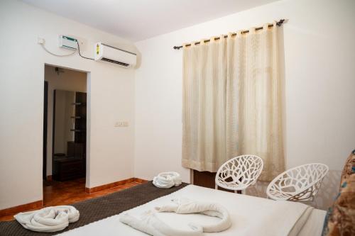 a room with a bed with two towels on it at Ronne's Candy Floss Blue Lagoon villa in Guirim
