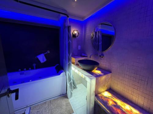 een badkamer met een wastafel, een bad en een spiegel bij CLOCKWORKORANGE Luxury Suites in Mactan