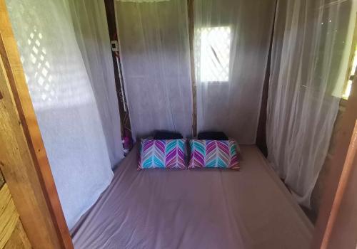 1 cama pequeña en una tienda de campaña con 2 almohadas en MIRA AgroPark en Tanay