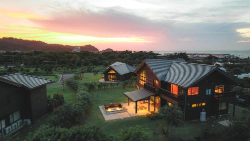 una vista aérea de una casa con puesta de sol en Cairns House by SANA en Tateyama