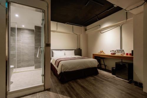 a bedroom with a bed and a walk in shower at Saturn Hotel in Taichung