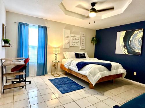 um quarto com uma cama e uma parede azul em Traveler Stay PLUS em Eagle Pass