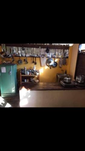La cuisine est équipée d'un réfrigérateur vert ainsi que de casseroles et de poêles. dans l'établissement บ้านริมน้ำประตูม่าน, à Ban Wiang Nua