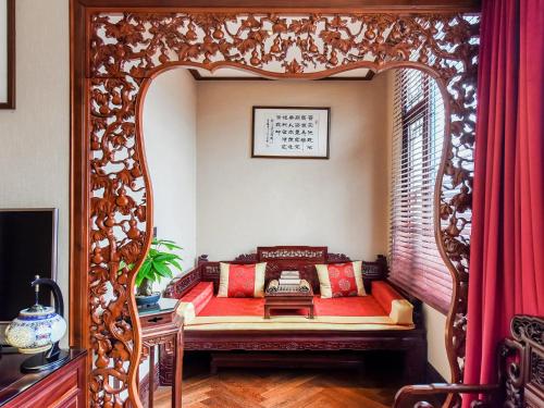 ChengDu Wuhou Temple Han Dynasty Hotel في تشنغدو: غرفة مزخرفة مع سرير في مرآة