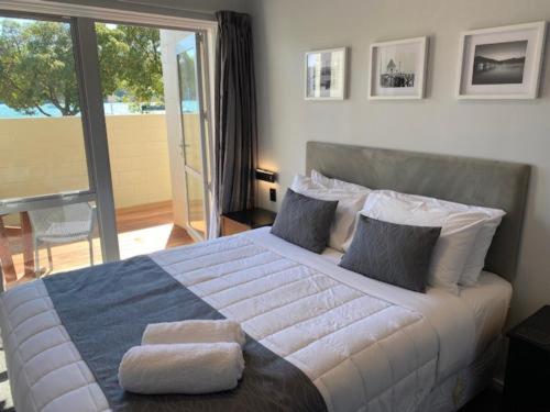 Akaroa Village Inn في أكارو: غرفة نوم بسرير كبير عليها منشفتين
