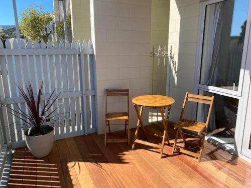 a porch with a table and two chairs and a window at Akaroa Village Inn in Akaroa