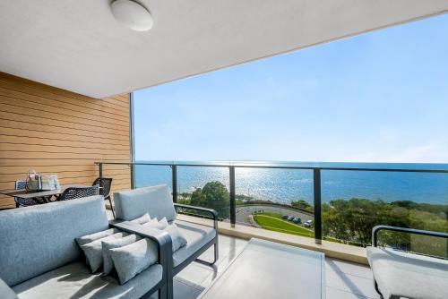 a living room with a view of the ocean at Oaks Redcliffe Mon Komo Suites in Redcliffe