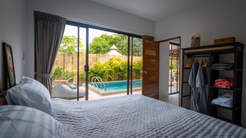 um quarto com uma cama e vista para uma piscina em Temple villas Koh Phangan em Ko Phangan