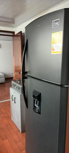 - un réfrigérateur en acier inoxydable dans la cuisine équipée d'une cuisinière dans l'établissement Casa frente Universidad de Manizales 4 habitaciones cerca al centro de la ciudad, à Manizales