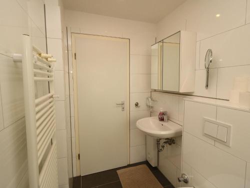 a white bathroom with a sink and a mirror at Property in Essen in Essen