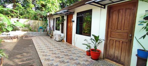 ein Haus mit einer Tür und Pflanzen davor in der Unterkunft Cozy 1-bedroom house in quiet residential village. in Iloilo City