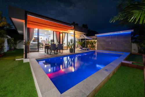 a swimming pool in the backyard of a house at night at Mango Hill Residence in Rawai Beach