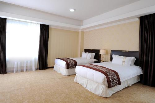 a hotel room with two beds and a window at Alpha Hotel Ulaanbaatar in Ulaanbaatar