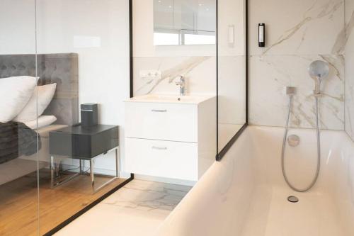 a white bathroom with a shower and a sink at My Perfect Penthouse in Vienna