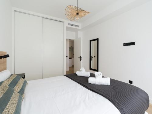 una camera da letto con un grande letto bianco con due asciugamani di Pascal Home By CanariasGetaway a Las Palmas de Gran Canaria