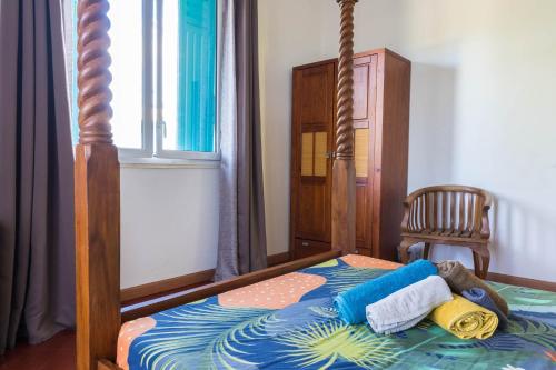 1 dormitorio con cama con dosel y toallas. en villa Anthalo, en La Saline-Les-Bains