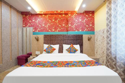 um quarto com uma grande cama branca com almofadas coloridas em FabHotel RS Residency em Kakarmatha