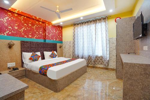 a bedroom with a large bed and a television at FabHotel RS Residency in Kakarmatha
