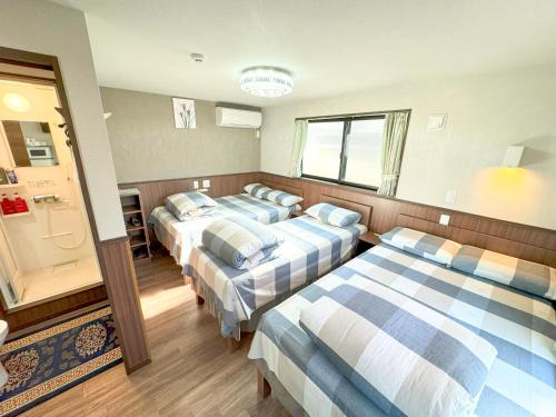 a room with three beds and a bathroom at SHINJUKU WARM VILLA I in Tokyo