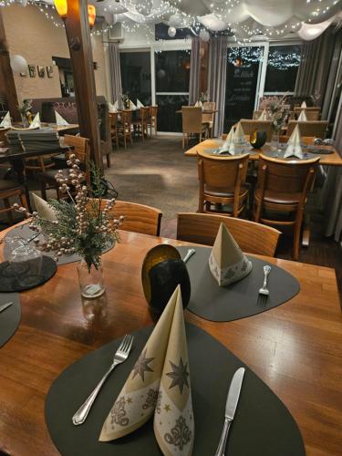 a table with napkins and utensils on a table in a restaurant at Hotel Sonnenhof in Perl