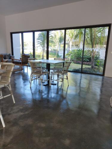 a dining room with a table and chairs and windows at Apartment in a Tropical Oasis, Ki Residences, Pereybere - Managed by KSN in Pereybere