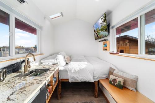 uma cama num quarto com um lavatório e janelas em Blue Moon Tiny House, Sauna,ht em Port Angeles