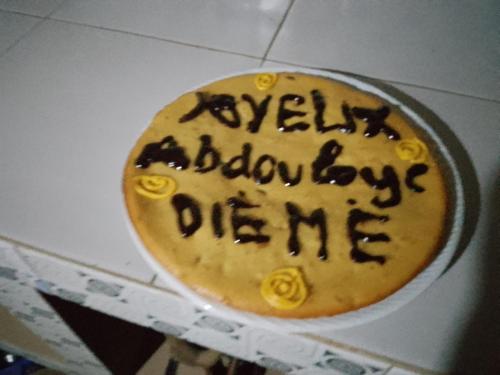 un gâteau d'anniversaire avec écriture dans une boîte dans l'établissement assoukatene lodge, à Cap Skirring