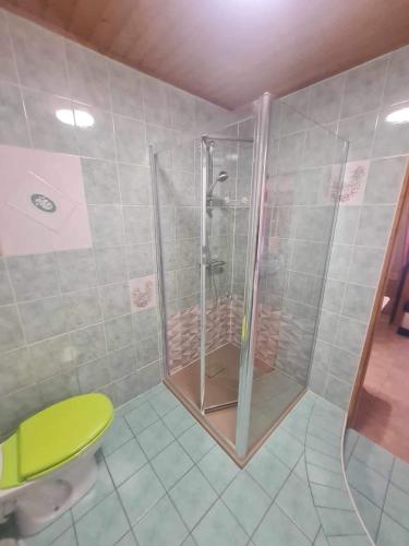La salle de bains est pourvue d'une douche avec un tabouret jaune. dans l'établissement Maison mitoyenne avec terrasse, à Villar-Saint-Pancrace