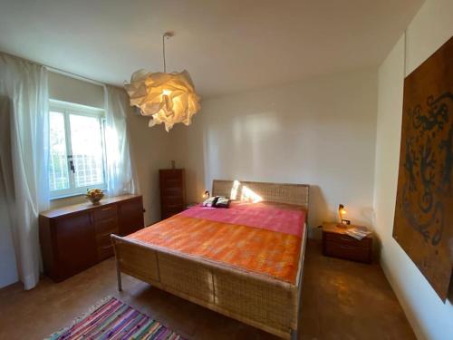 ein Schlafzimmer mit einem großen Bett und einem Kronleuchter in der Unterkunft Seele baumeln lassen im Olivenhain (Meeresnähe) in Santa Caterina dello Ionio