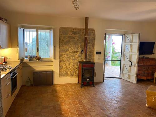 eine Küche mit einer Steinmauer und einem Herd in der Unterkunft Seele baumeln lassen im Olivenhain (Meeresnähe) in Santa Caterina dello Ionio