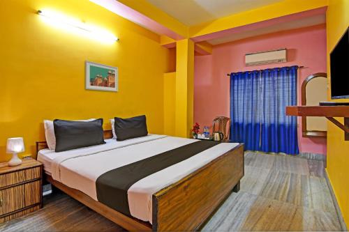 a bedroom with a bed with yellow and red walls at Flagship Hotel Red Rose Near Noapara Metro Station in Kolkata