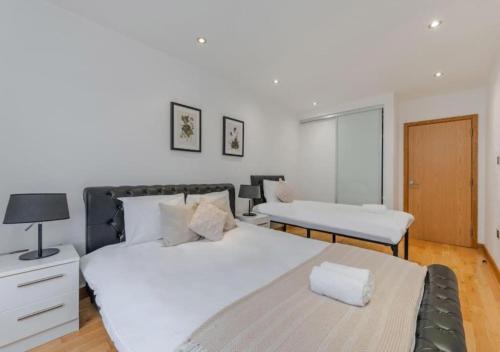 1 dormitorio con 2 camas, mesa y lámpara en Kensington & Chelsea - Stylish Apartment in Central London, en Londres