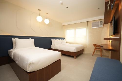 a hotel room with two beds and a desk at Athlete's House in Imus