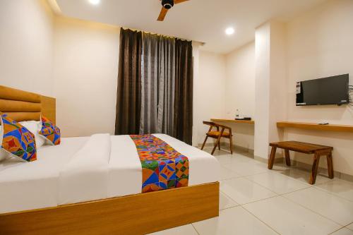 una habitación de hotel con una cama y un televisor en FabHotel The Gravity Inn, en Indore