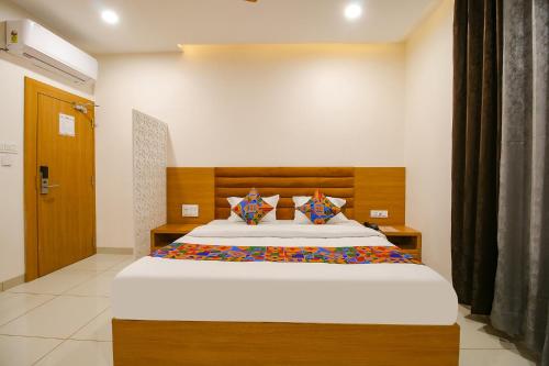1 dormitorio con 1 cama grande y cabecero de madera en FabHotel The Gravity Inn, en Indore