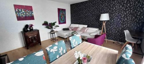 a living room with a table and a couch at Armorino - Appartement Charmant 2 Chambres - Proximité de tout in Lannion