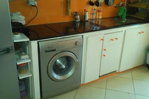 a kitchen with a washing machine under a counter at Apartamento en Tetuán in Tetouan