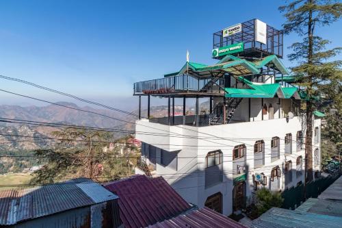 un bâtiment avec un balcon au-dessus dans l'établissement Treebo Trend Varuna With Mountain View, à Shimla