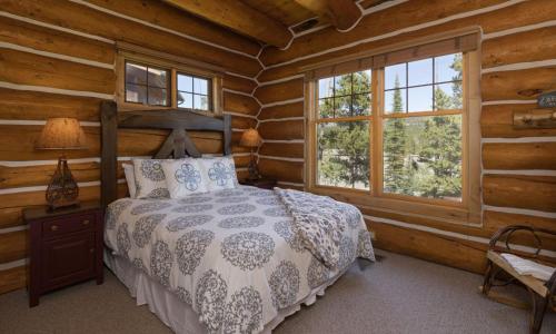 - une chambre avec un lit dans une cabane en rondins dans l'établissement Powder Ridge Cabin Rosebud 7, à Big Sky