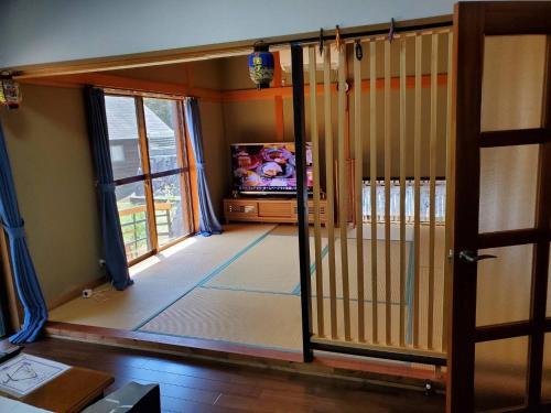 a living room with a tv and a sliding glass door at Oyado Nagomi - Vacation STAY 29876v in Takamatsu