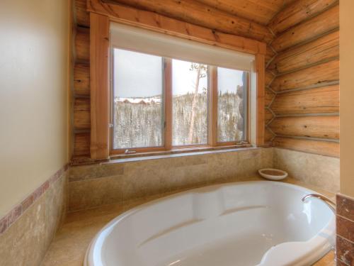uma banheira num quarto com uma janela em MV Big Dog Lodge em Big Sky