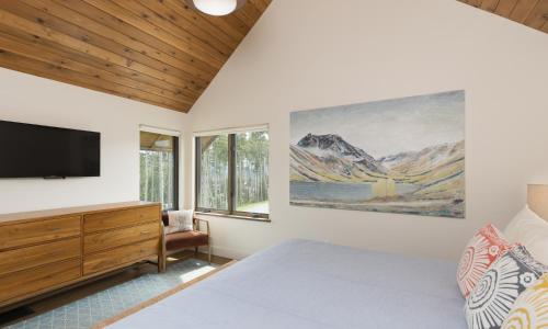 1 dormitorio con 1 cama y TV en la pared en Silvertip Cabin 16 Alpine Bend, en Big Sky