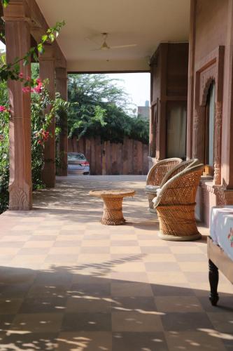 a patio with wicker chairs and a table at Kot Dunara - A 16th Century Castle near Jodhpur in Jodhpur