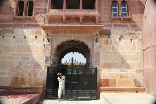 a person standing at the gate of a building at Kot Dunara - A 16th Century Castle near Jodhpur in Jodhpur