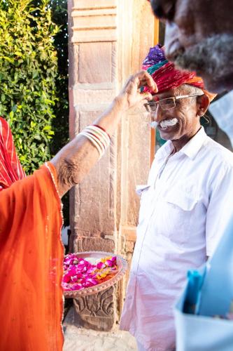 an older man with a red bandanna on his head at Kot Dunara - A 16th Century Castle near Jodhpur in Jodhpur