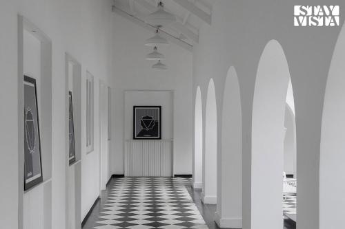 a hallway with a black and white checkered floor at The Mudra Manor 4BR Coorg temperature controlled pool Villa in Madikeri