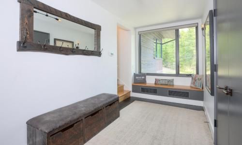 a room with a bench and a window and a mirror at Lake Cabin 19 Lakewood in Big Sky