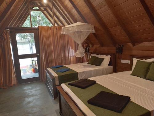 1 Schlafzimmer mit 2 Betten in einer Holzhütte in der Unterkunft Habarana New Star Homestay in Habarana