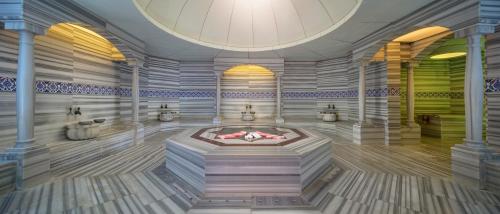 a room with a fireplace in the middle of a building at Aydinbey King's Palace & Spa - Ultra All Inclusive in Side